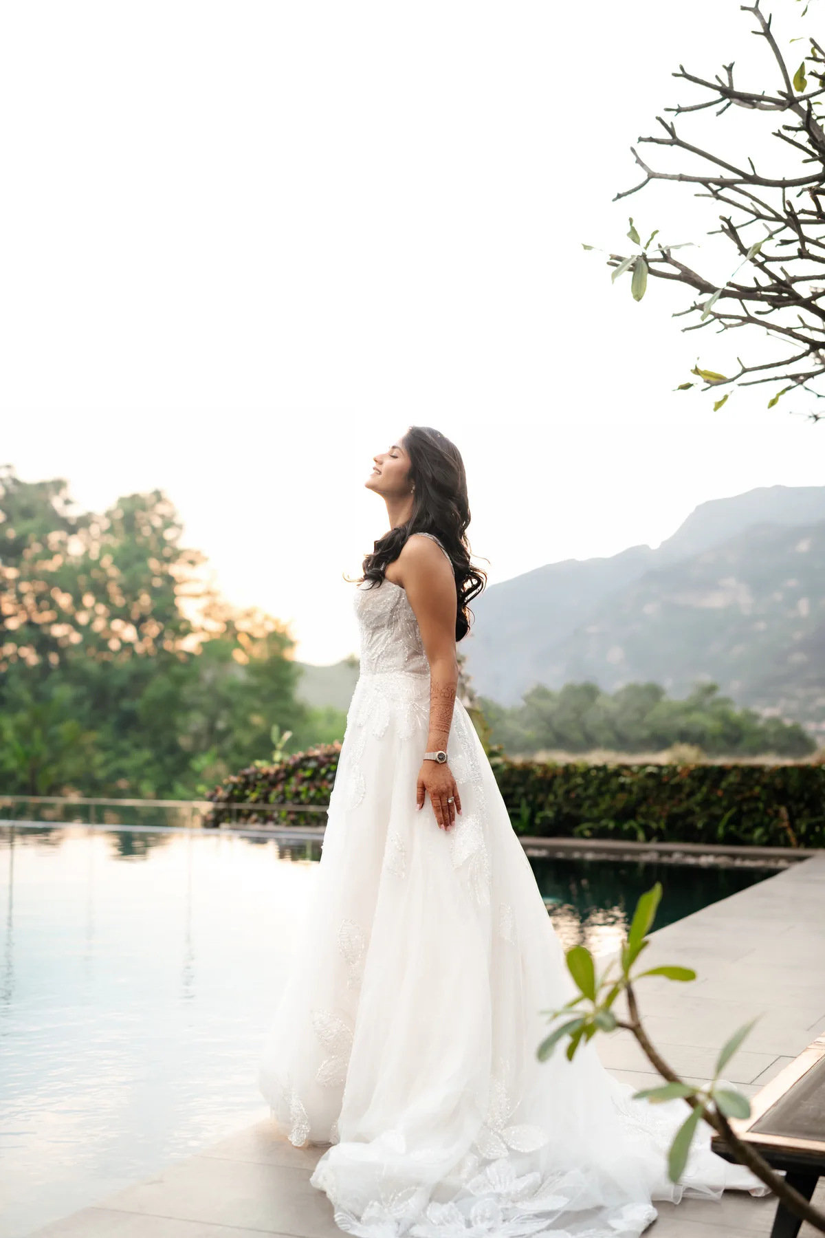 Portrait of a woman in a white wedding dress beside a pool